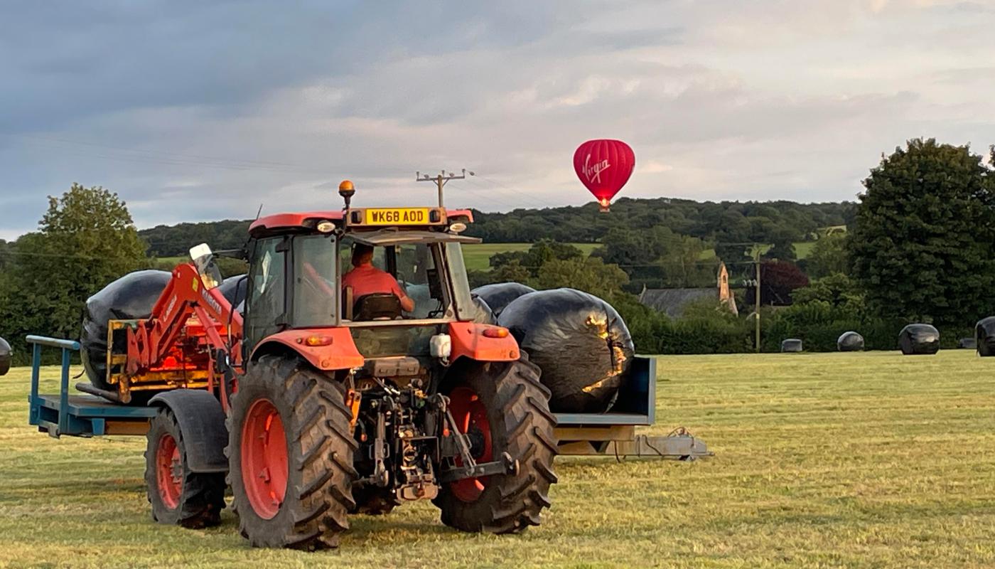 Tractor with hot air balloon in the background